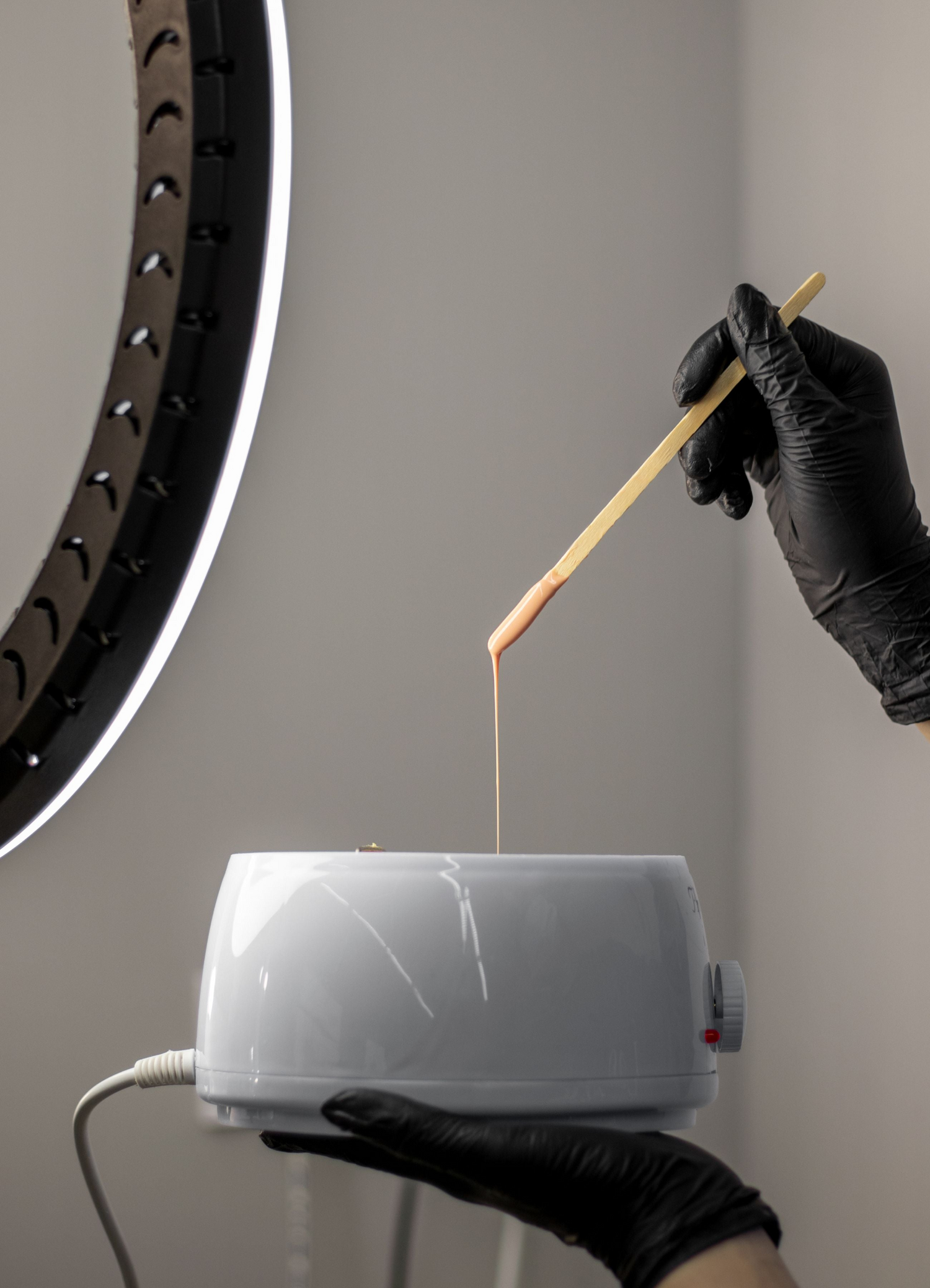 Esthéticienne préparant une cire pour l'épilation à la clinique esthétique Skin & Co Esthétique situé à Québec